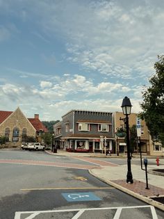 an empty street with buildings and cars parked on the side