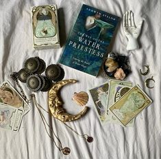 there are many items that can be seen on the bed, including books and jewelry