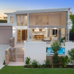 a house with a pool in front of it and landscaping around the back yard area