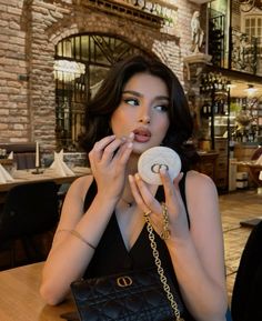 a woman sitting at a table with a doughnut in her hand