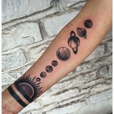 an arm tattoo with planets and sun on it