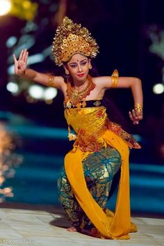 a woman dressed in an elaborately designed costume is dancing with her arms outstretched and hands out