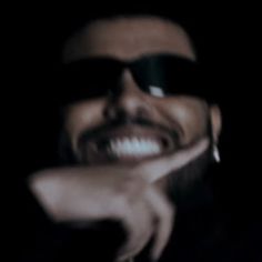 a man with sunglasses on his face smiling