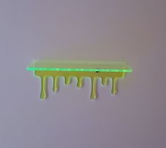 a piece of neon green paint dripping down the side of a wall