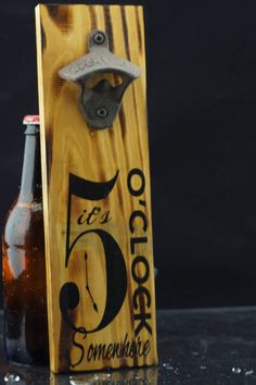 a wooden bottle opener sitting next to a beer