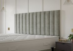 an upholstered headboard on top of a bed in a room with white walls