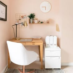 a desk and chair in a room with a clock on the wall next to it