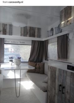 the inside of a camper with windows and curtains