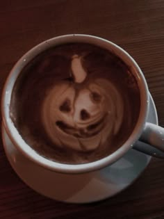 a coffee cup with a smiley face drawn on the foam in it's bottom