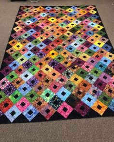 a multicolored patchwork quilt on the floor