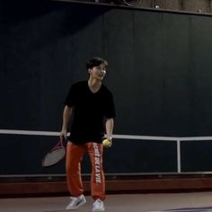 a young man holding a tennis racquet on top of a tennis ball court