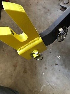 a close up of a yellow bike handle on a metal object in a garage area