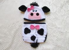 a crocheted cow with a pink bow on it's head