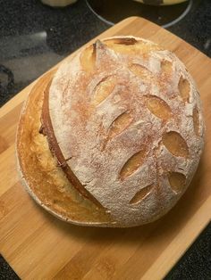 a loaf of bread sitting on top of a wooden cutting board