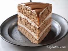 a piece of cake on a plate with chocolate frosting and caramel drizzle