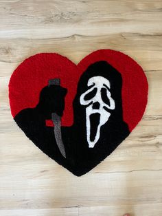 a heart shaped rug with a man holding a knife in his hand on top of a wooden floor