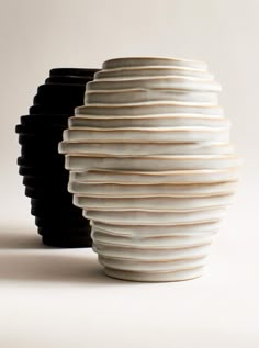 several black and white vases stacked on top of each other