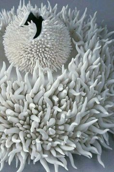 a sculpture made out of white corals with a black bird perched on it's head