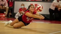 a female volleyball player dives for the ball