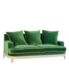 a green couch with four pillows on it