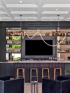 a bar with chairs and a television mounted to the wall