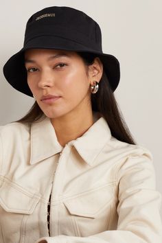 Jacquemus' 'Le Bob' bucket hat has quickly become a brand signature, returning each season in different colors and prints. This one is made from black cotton-canvas and is embellished with glossy logo lettering across the front. Black Bucket Hat Outfit, Hat Jacquemus, Jacquemus Bucket Hat, Jacquemus Hat, Glossier Logo, Bucket Hat Outfit, Designer Bucket Hats, Black Bucket Hat, Feed Insta