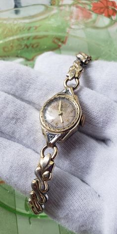 This is a rare, very pretty, Art Deco white and yellow gold filled 1937's, with 2 diamonds, Bulova women's mechanical watch. What a special piece of jewelry! There is a white gold and diamonds slightly extended bezel set in yellow gold, with beautuful textured Art Deco design. Simply beautiful! This special, dainty watch is in wonderful vintage condition,  showing how much it was cherished and loved.  It works well. Please see photos as they speak wonderfully to the beauty and condition of this rare bracelet! What a special watch that is sure to make a great addition to any jewelry collection!  An unforgettable gift idea as well! The flex band measures approximately 6 1/2".  This watch is running well currently but the service history is unknown so cannot guarantee how long it will run bef Dainty Gold Watch Vintage, Vintage Gold Watch Women’s, Watches For Women Classy, Bulova Watches Women, Dainty Watch, Vintage Bulova Watches, Textured Art, 1930s Art Deco, Mechanical Watch