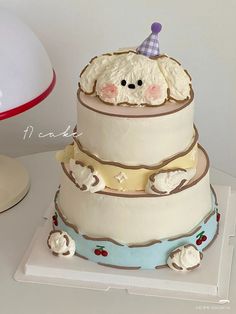 a three tiered cake with a teddy bear on top