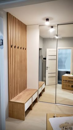 a wooden bench sitting in the middle of a living room next to a wall mounted mirror