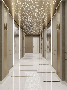 a long hallway with white and gold walls, flooring and lights on the ceiling