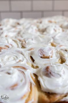 cinnamon rolls with icing sitting on top of a table