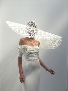 a woman in a white dress with a veil on her head and wings over her head