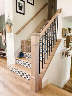 the stairs are decorated with black and white tiles on them, along with pictures hanging on the wall