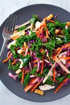 a plate full of salad with carrots, broccoli and croutons