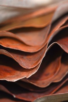 a pile of brown leather sheets sitting on top of each other