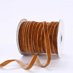 a spool of brown velvet cord on a white background