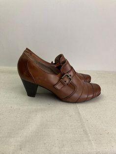 Women`s cognac brown leather loafers with adjustable sides straps and buckles, chunky heeled boho style shoes. Size 7 1/2 UK. Germany shoes. Casual shoes. The elastic gums on the top. Comfy shoes. Booties with round toes. European quality autumn fall/spring footwear.  labeled materials: LEATHER upper and vegan leather insole. condition: a little bit used, but in very good condition.  Without serious damages. Some slight scratches on the toes. Look at the photos - no.2. and 3.  measurements: outs Retro Brown Round Toe Loafers, Retro Brown Loafers With Round Toe, Brown Monk Strap Shoes With Buckle Closure, Vintage Brown Monk Strap Shoes With Round Toe, Brown Heels With Buckle Closure And Round Toe, Vintage Leather Heels With Buckle Closure, Vintage Brown Round Toe Loafers, Vintage Brown Loafers With Round Toe, Brown Pointed Toe Loafers With Buckle