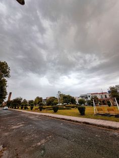 a skateboarder doing a trick in the air on a cloudy day at an urban park