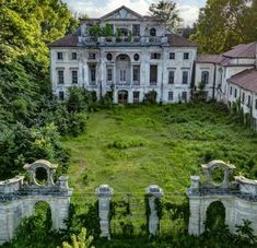 an old mansion with ivy growing on the roof and walls, surrounded by lush green trees