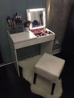 a white vanity with lights on it and a stool