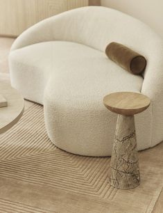 a white couch sitting on top of a wooden floor next to a table and chair