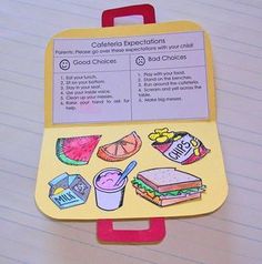 a lunch box with food on it sitting on top of a piece of paper