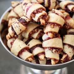 a metal bowl filled with cranberry pastries on top of a silver table