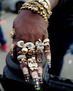 a person's hand with rings and bracelets on it