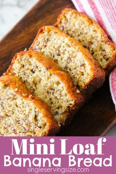 three slices of banana bread sitting on top of a wooden cutting board next to a red and white towel