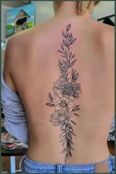 a woman's back tattoo with flowers on it