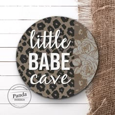 a badge with the words little babe cave on it and an image of a leopard print