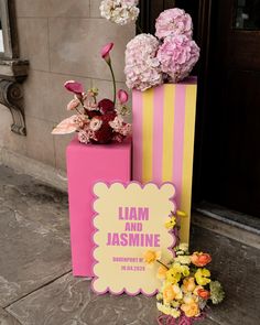 pink and yellow boxes with flowers in them on the ground next to a sign that says i am and jasmine