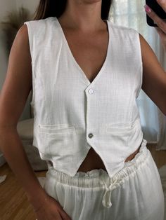 Our new linen vest top! Comes in White, Black and Brown. It features a looser fit, slightly cropped silhouette, and delicate button detailing. Look effortlessly chic by dressing it up with some jeans or pairing it with our Linen Love Pants for a complete matching linen fit!! Maclaine is 5'7 and wearing size Small. This is a looser fit! 70% Rayon 30% Linen Cropped Summer Vest With Pockets, Spring Linen Vest For Day Out, Chic Button-up Cotton Tank Top, Chic Cotton Button-up Tank Top, Chic Linen Vest For Day Out, Casual Everyday Linen Vest, Chic Cotton Tank Top With Buttons, Chic White Vest For Everyday Wear, Chic White Vest For Everyday