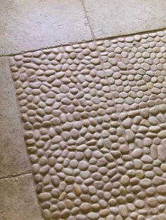 a close up of a tile floor with rocks on it